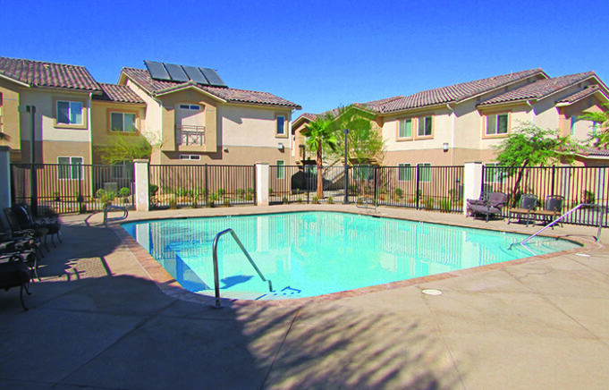 Property building exterior and pool with iron fencing